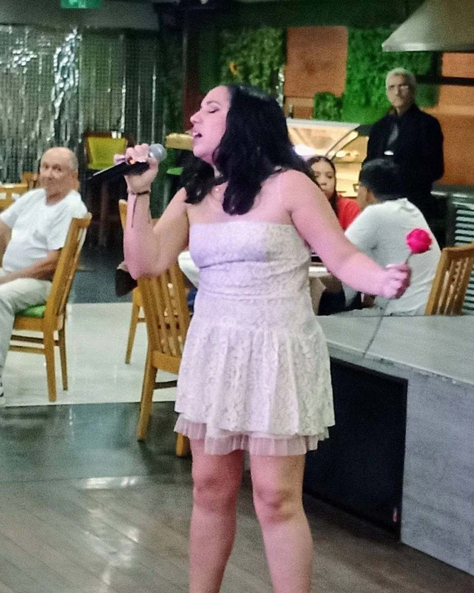 Emma Colmenares, segundo lugar de la segunda edición, cantando con una rosa