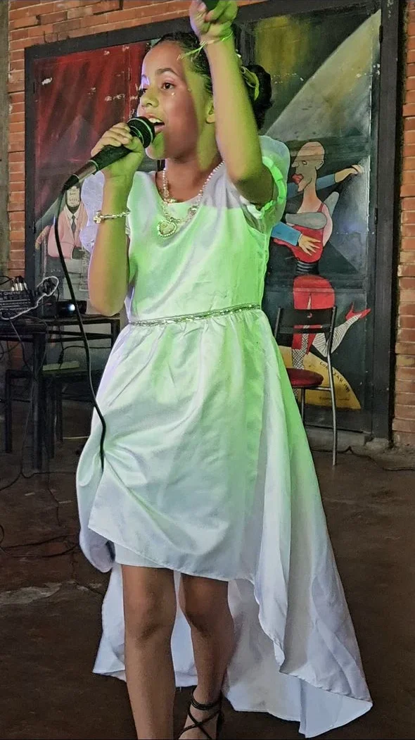 Esmeralda Fernández, tercer lugar de la primera edición, cantando con vestido blanco