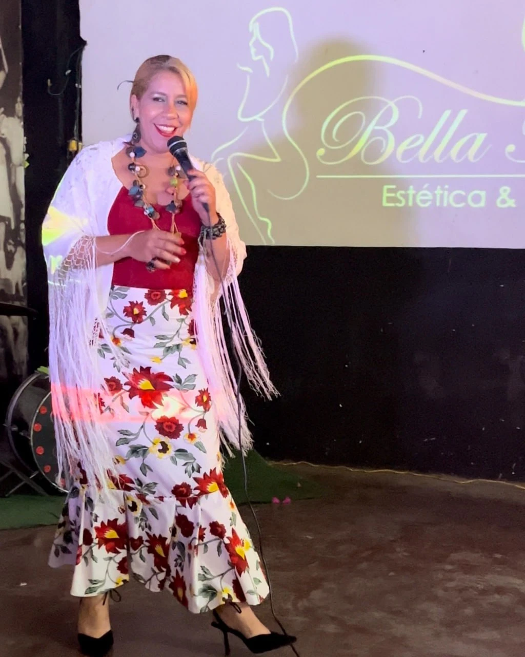 Marianella Arvelaiz, primer lugar de la primera edición, cantando con falda floreada y mantón blanco